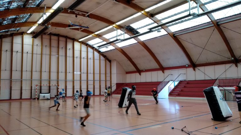 Joueurs en pleine partie d'Archery Touch, à couvert derrière un bunker gonflable